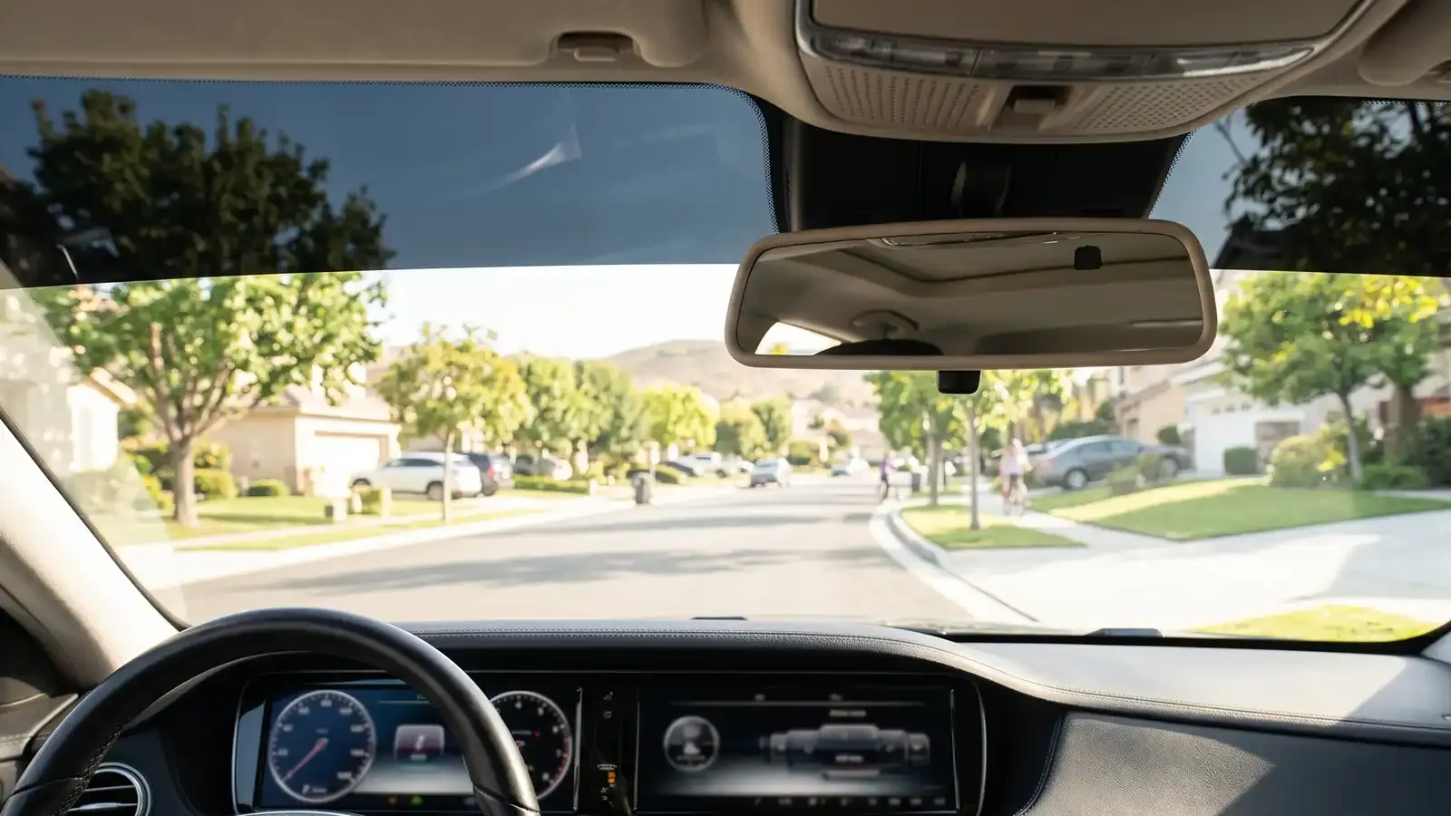 Interior view of a windshield with a legal non-reflective tint strip on the top six inches and clear glass below, per New York VLT law.